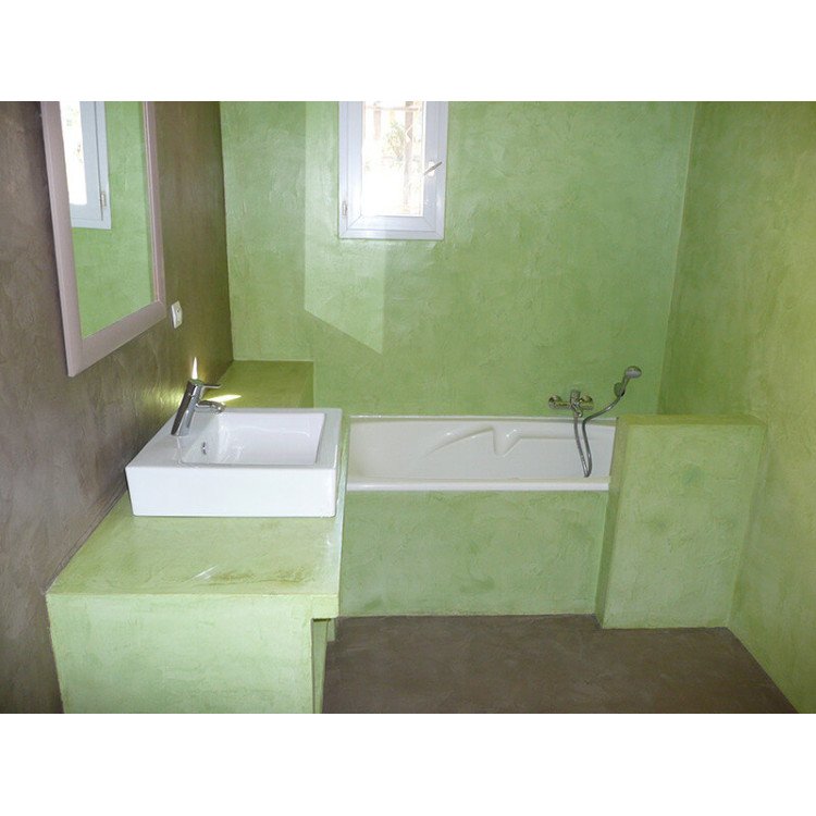Salle de bain avec murs vert clair, baignoire encastrée et lavabo blanc sur une meuble vert, fenêtre et miroir au fond. Couleur déconseillée pour une salle de bain.